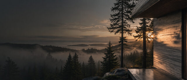 Fog over the Salish Sea at first light, seen past the board-formed wall of a Hillcrest house.