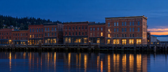 The Port Townsend warehouse row at blue hour, seen from the water.